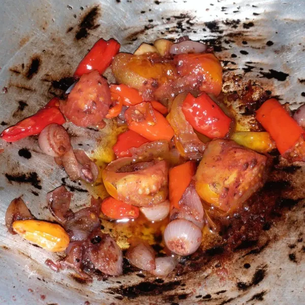 Masukkan cabai dan tomat, aduk dan tutup wajan, biarkan hingga tomat layu, gunakan api kecil