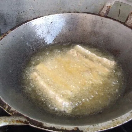 Panaskan minyak, lalu goreng tempe dengan api sedang cenderung kecil hingga matang