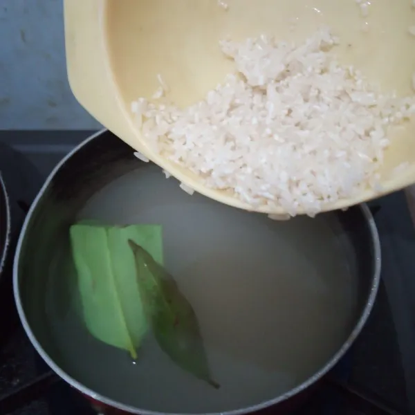 Rebus kaldu ayam dan daun salam kemudian masukkan beras, aduk terus. Masak dengan api kecil
