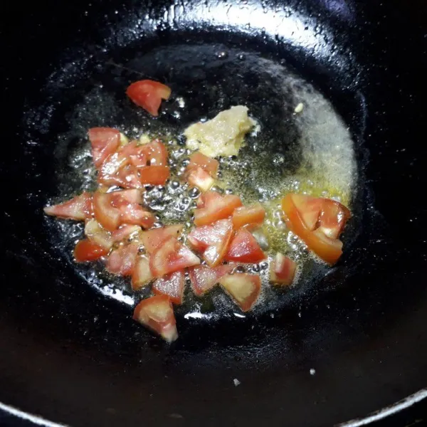 Tumis bawang putih halus dan tomat hingga harum