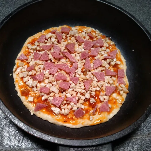 Ambil tempe cincang tabur di atas saos bolognese. Lalu tata irisan smoke beef di atas tempe