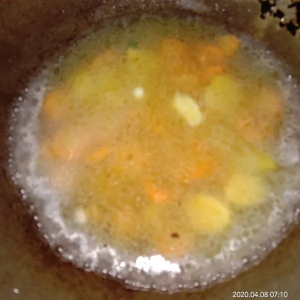 Tambahkan air, wortel dan kentang yang sudah dipotong kecil-kecil hingga empuk.