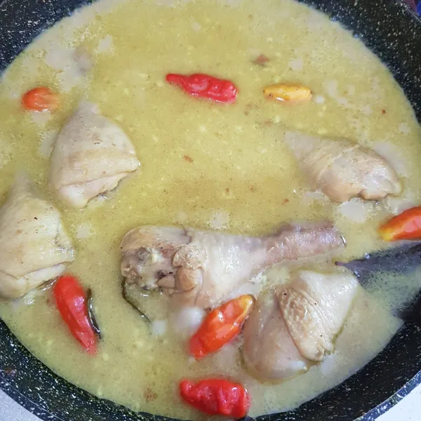 Setelah ayam matang, tambahkan santan kental dan cabai rawit. Masak sambil diaduk hingga kuah mengental