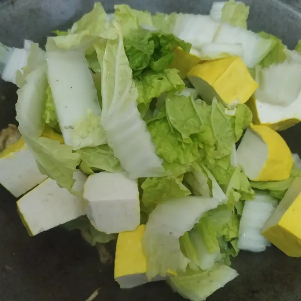 Lalu masukkan tahu dan sawi, aduk rata