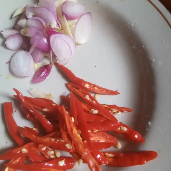 Potong cabe merah dan iris bawang merah dan bawang putih.