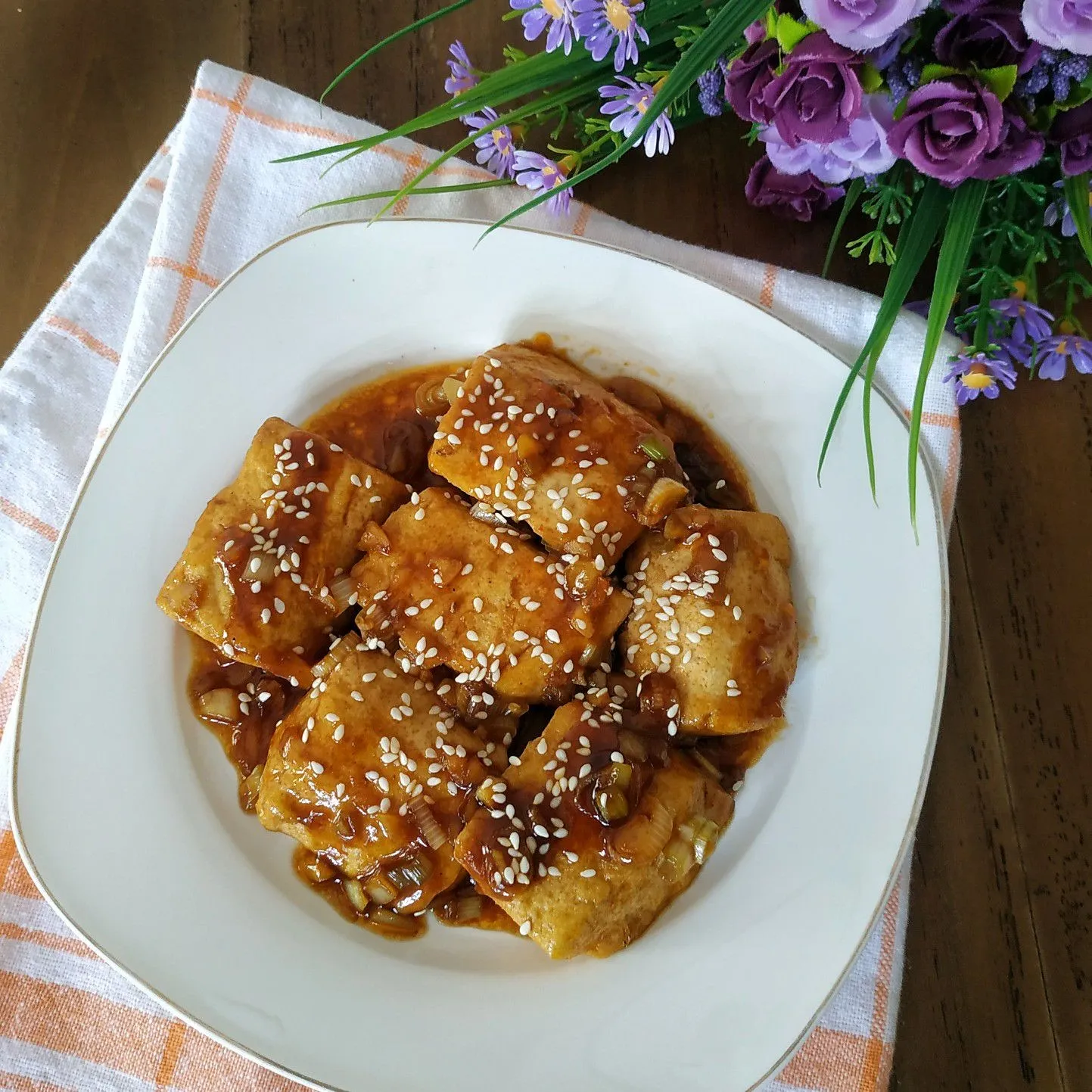 Tahu balut dalam mangkuk dengan saus cabai di sampingnya