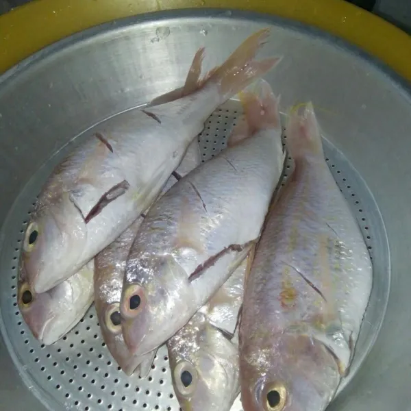 Cuci bersih ikan dari bau amis.