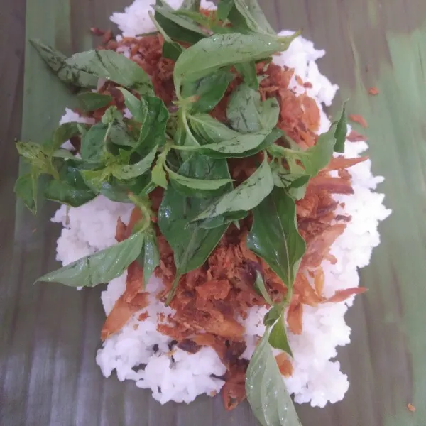 Siapkan daun pisang yang sebelumnya di panaskan di atas kompor terlebih dahulu supaya mudah saat membungkus. Susun nasi, ikan cakalang suwir, dan kemangi. Lalu bungkus.