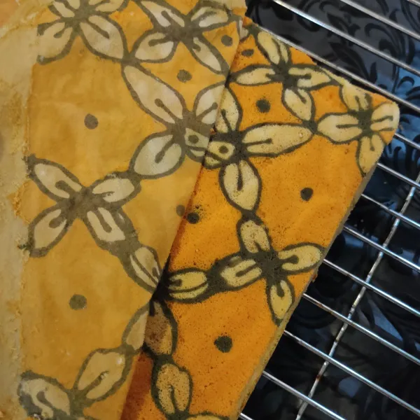 Kemudian, posisikan cake dengan terbalik di atas cooling rack, lalu ambil kertas roti, hingga tampak motif batiknya. Siap disajikan