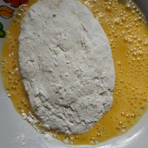 Gulingkan ke tepung terigu, kemudian ke kocokan telur