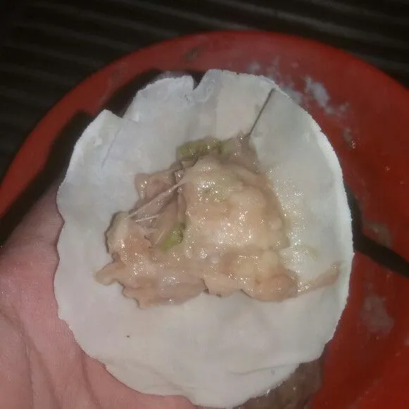 Ambil selembar kulit dumpling isi dengan 1/2 sdm isian, lalu cubit-cubit kecil bagian pinggirannya hingga seluruh pinghirnya tertutup. Lakukan hingga adonan habis