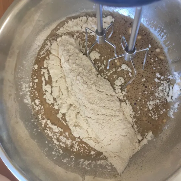 Setelah tercampur rata, masukkan tepung terigu dan baking powder, kemudian aduk lagi hingga tercampur.