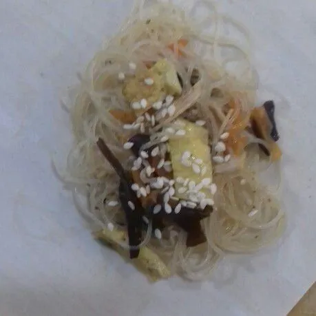 Ambil selembar kulit lumpia, beri sesendok japchae, taburi wijen