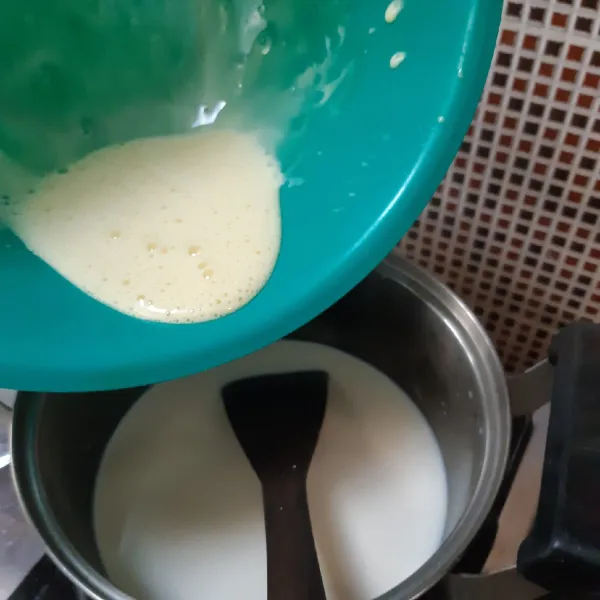 Masak susu dgn api kecil di panci sambil terus di aduk pelan hingga meletup. Kemudian tambahkan perisa vanilla, garam dan 2 sdm gula sampai larut. Masukkan adonan kuning telur sampai tercampur rata. Tunggu mendidih.