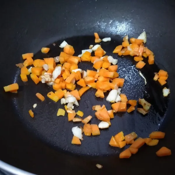 Tumis bawang putih hingga harum. Kemudian masukkan wortel. Aduk
