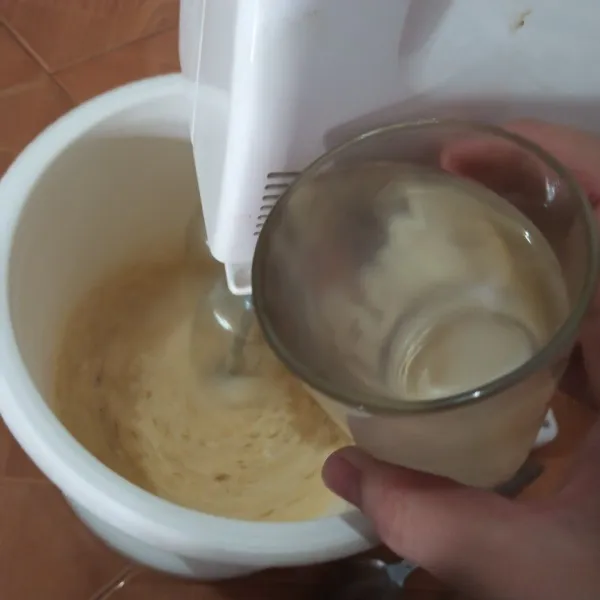 Nyalakan mixer di speed 2, kocok dan masukkan air perlahan.