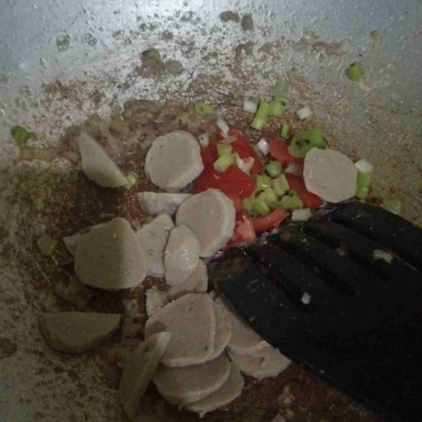 Kemudian masukkan potongan baso, tomat dan daun bawang, aduk rata.