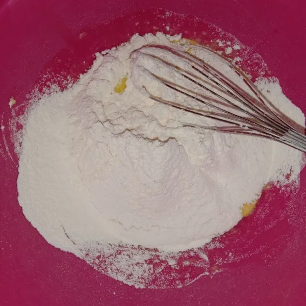 Tambahkan tepung terigu yang sudah diayak, aduk rata, pelan saja