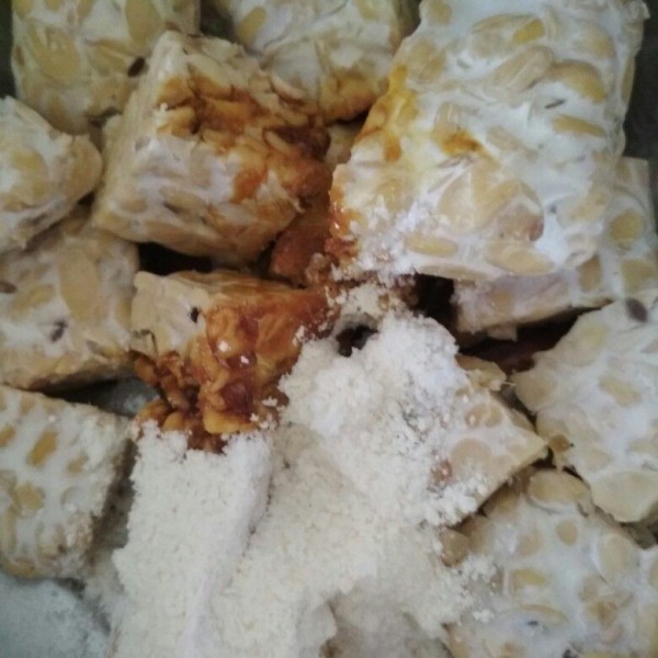 Setelah tempe dikukus tambahkan kecap manis, terigu dan garam, haluskan tempe dan campur hingga rata