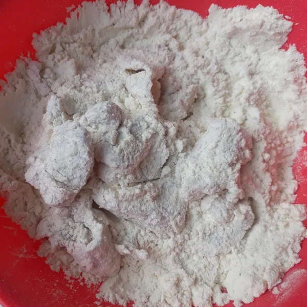 Masukkan ayam yang sudah direndam dengan bumbu ke tepung pelapis lalu aduk hingga terbalut