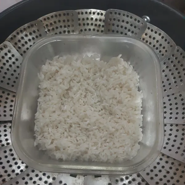 Kukus ketan dalam dandang hingga setengah matang