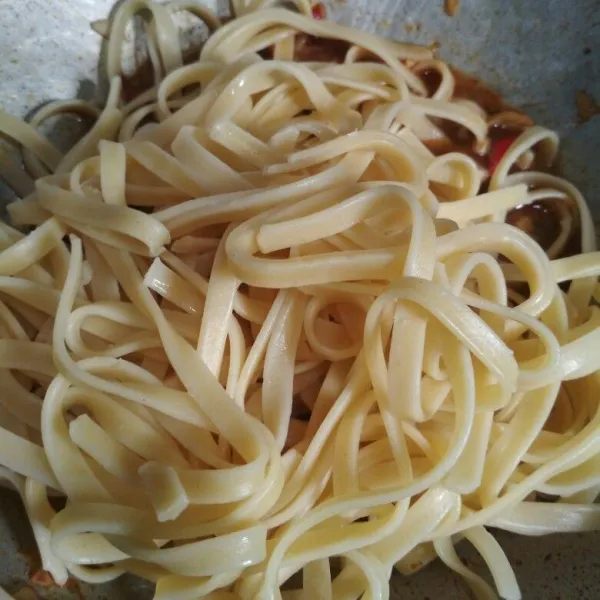Tambahkan pasta fettuccini aduk hingga rata tambahkan lada bubuk, garam dan gula pasir sebagai penyeimbang rasa, koreksi rasa