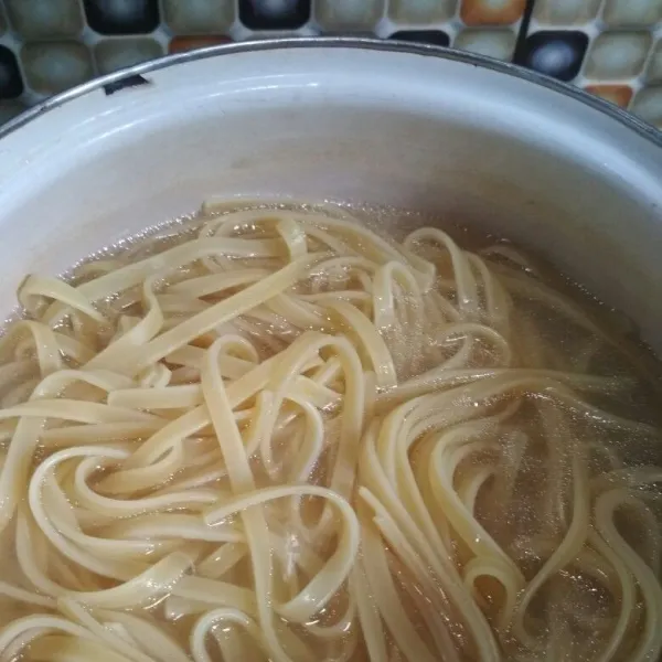 Rebus fettuccini dengan sedikit minyak hingga al dente, angkat tiriskan