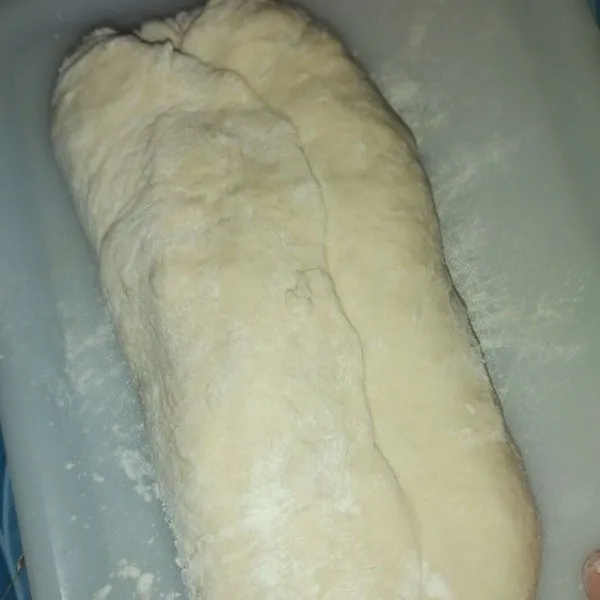 Setelah mengembang, kempiskan lalu baluri tepung dan lipat adonan memanjang