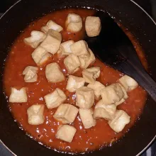 Masukkan tahu goreng ke dalam saus, aduk rata sampai bumbu meresap