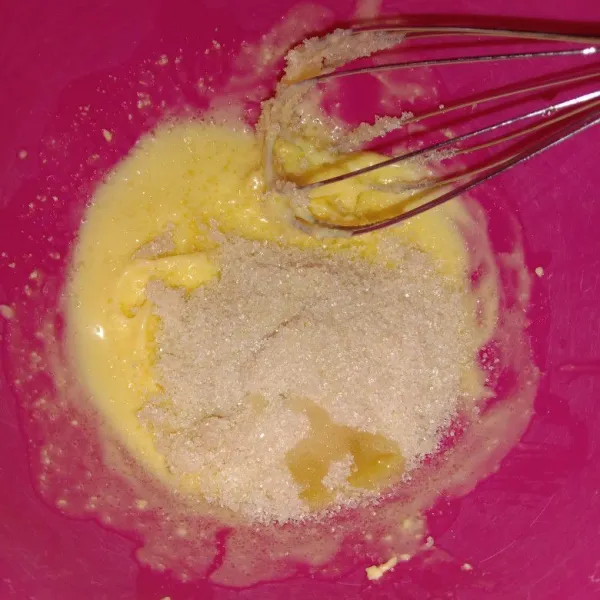 Dalam wadah masukkan margarine dan minyak goreng kemudian kocok menggunakan whisker hingga creamy lalu tambahkan gula pasir dan vanilla cair, aduk hingga rata