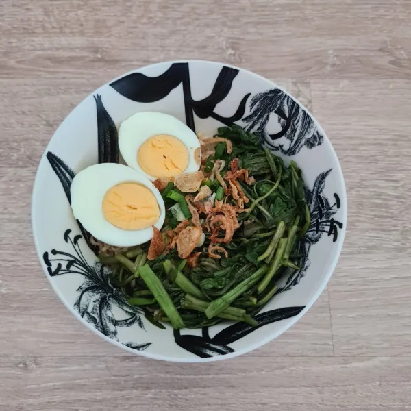 Tata mie, kangkung, telur rebus, daun bawang dan bawang goreng di mangkok. Siram dengan kuah dan ayam. Mie kangkung siap dinikmati