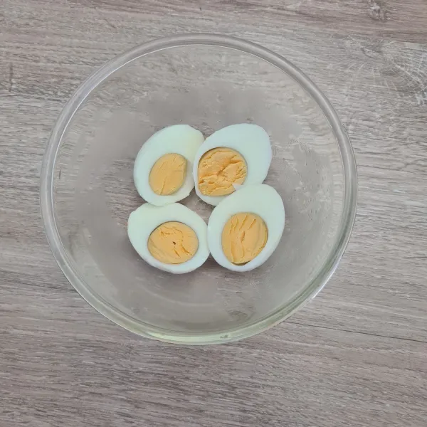 Rebus telur dan potong jadi 2 bagian. Sisihkan