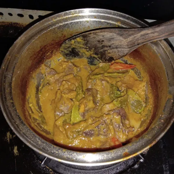 Masak rendang menggunakan api sedang sambil terus diaduk-aduk hingga santan mengental, cek rasa jika sudah pas tetap aduk rendang hingga kuah mulai menyusut dan daging empuk, matikan api, angkat dan siap disajikan