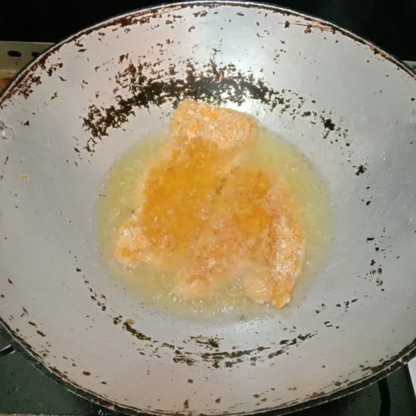 Panaskan secukupnya minyak goreng menggunakan api sedang kemudian goreng ayam katsu hingga kuning kecoklatan dan matang, angkat, tiriskan