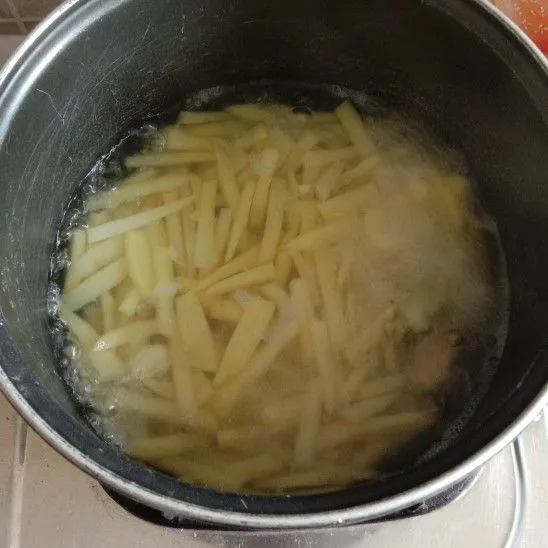 Cuci bersih kentang, lalu potong secara memanjang. Kemudian rebus kentang dan masukkan garam dan bawang putih yang sudah di geprek. Rebus dengan api sedang selama 5 menit.