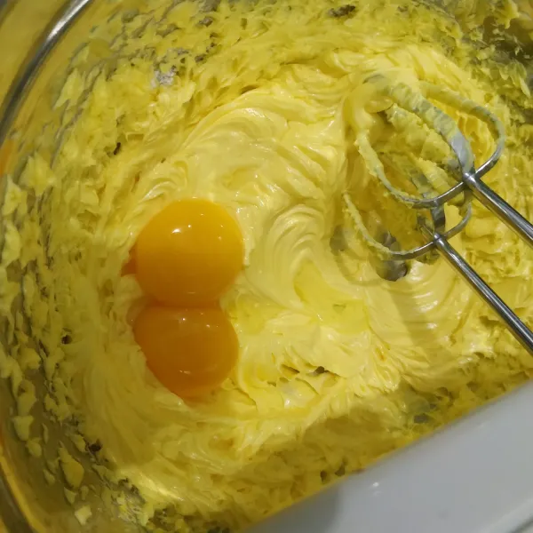 Masukkan kuning telur. Mixer dengan kecepatan sedang sampai tercampur rata.
