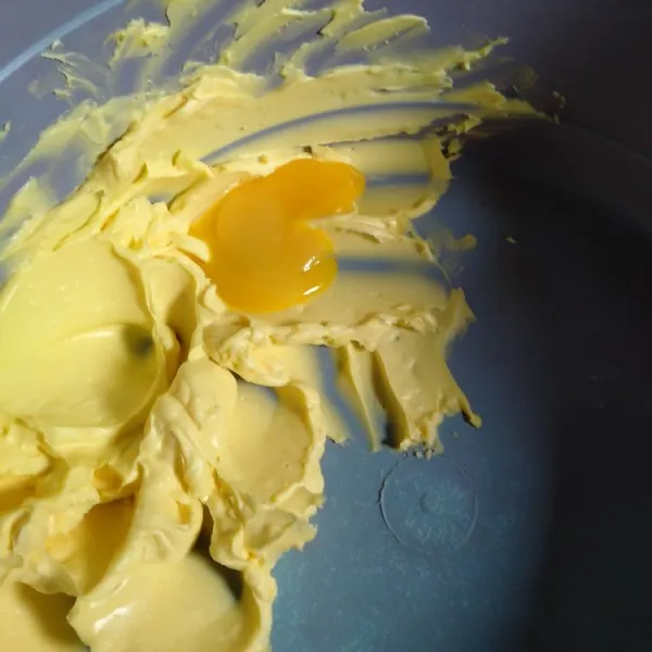 Kocok margarin dan kuning telur hingga tercampur rata.