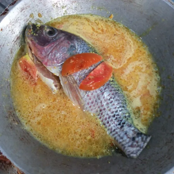 kemudian masukkan air secukupnya rebus sampai mendidih dan masukkan ikan, tomat. masak sampai ikan matang