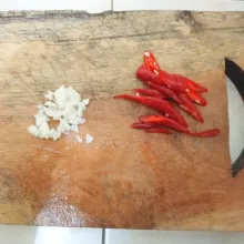Iris tipis-tipis bawang putih dan cabe merah.