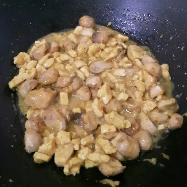 Masukkan potongan dadu ayam, aduk rata. Masak sampai berubah warna lalu masukkan potongan jamur, aduk hingga rata lagi.