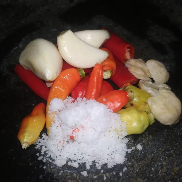 Siapkan bumbu yang akan diulek yaitu bawang putih, cabai merah, cabai rawit, garam, dan kemiri. Ulek halus kemudian masukan gula dan ulek kembali.