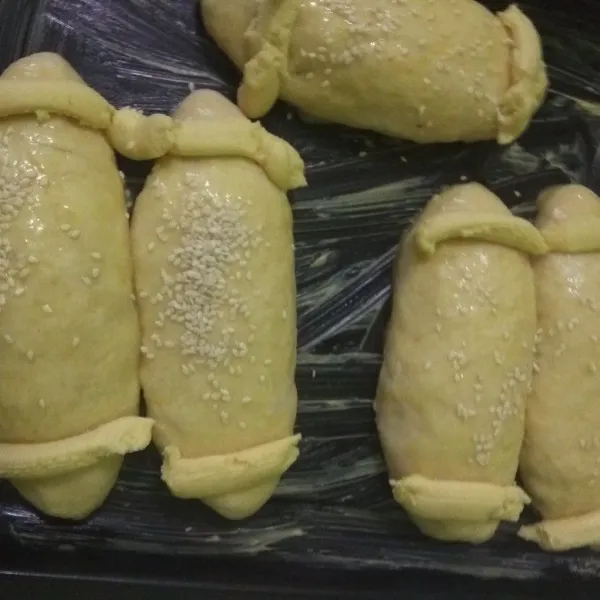 tata diloyang yang sudah dioles margarin tipis.semprot pinggirnya dengan topping(saya ga rapih,harusnya pake plastik segitiga.saya kehabisan plastiknya jadi gunakan yg ada).oles dengan polesan taburi dengan wijen