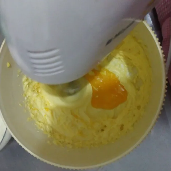 Tambahkan kuning telur satu persatu, kocok kembali hanya sampai tercampur rata. Matikan mixer.