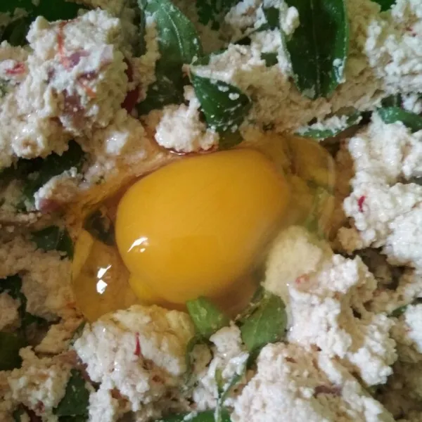 Tambahkan daun kemangi, aduk rata kemudian pecahkan satu butir telur lalu aduk rata.