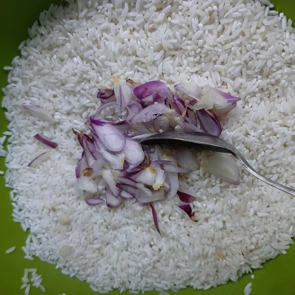 Di wadah lain, masukan beras yang sudah dicuci, tambahkan potongan bawang aduk-aduk