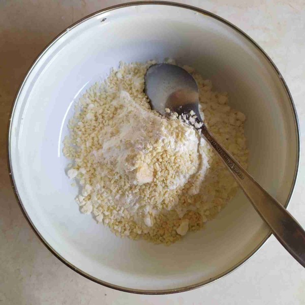Dalam wadah, campur tepung terigu, maizena, baking powder, gula pasir, wijen, dan esens vanila