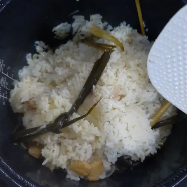 Setelah matang aduk-aduk nasi. Sajikan bersama ayam, kuah kaldu dan taburan daun bawang