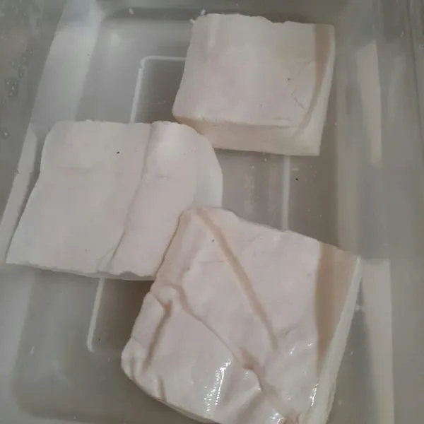 Rendam tahu dengan air hangat dan garam,