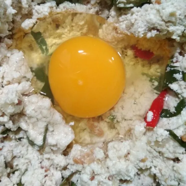 Tambahkan telur aduk rata, ambil cetakan/alumunium foil cup. Oles dengan sedikit minyak kemudian sendokkan adonan dan padatkan.