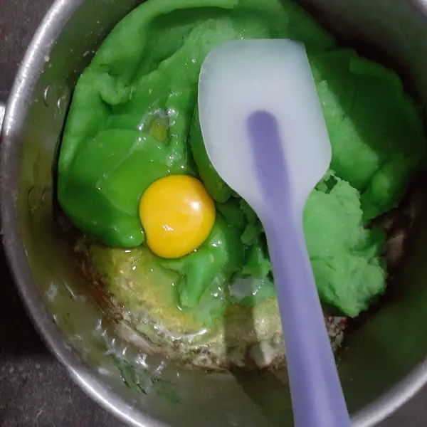 Setelah adonan dingin, masukkan telur. Aduk sampai adonan tercampur, dan tekstur adonan menjadi berat.